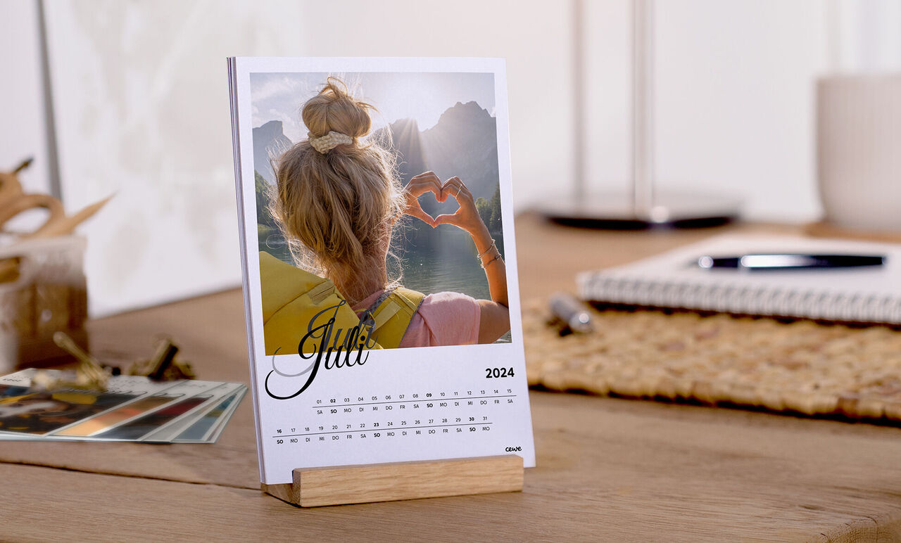 Besplatni stolni kalendar za lipanj 2025. s fotografijom osobe koja rukama oblikuje srce